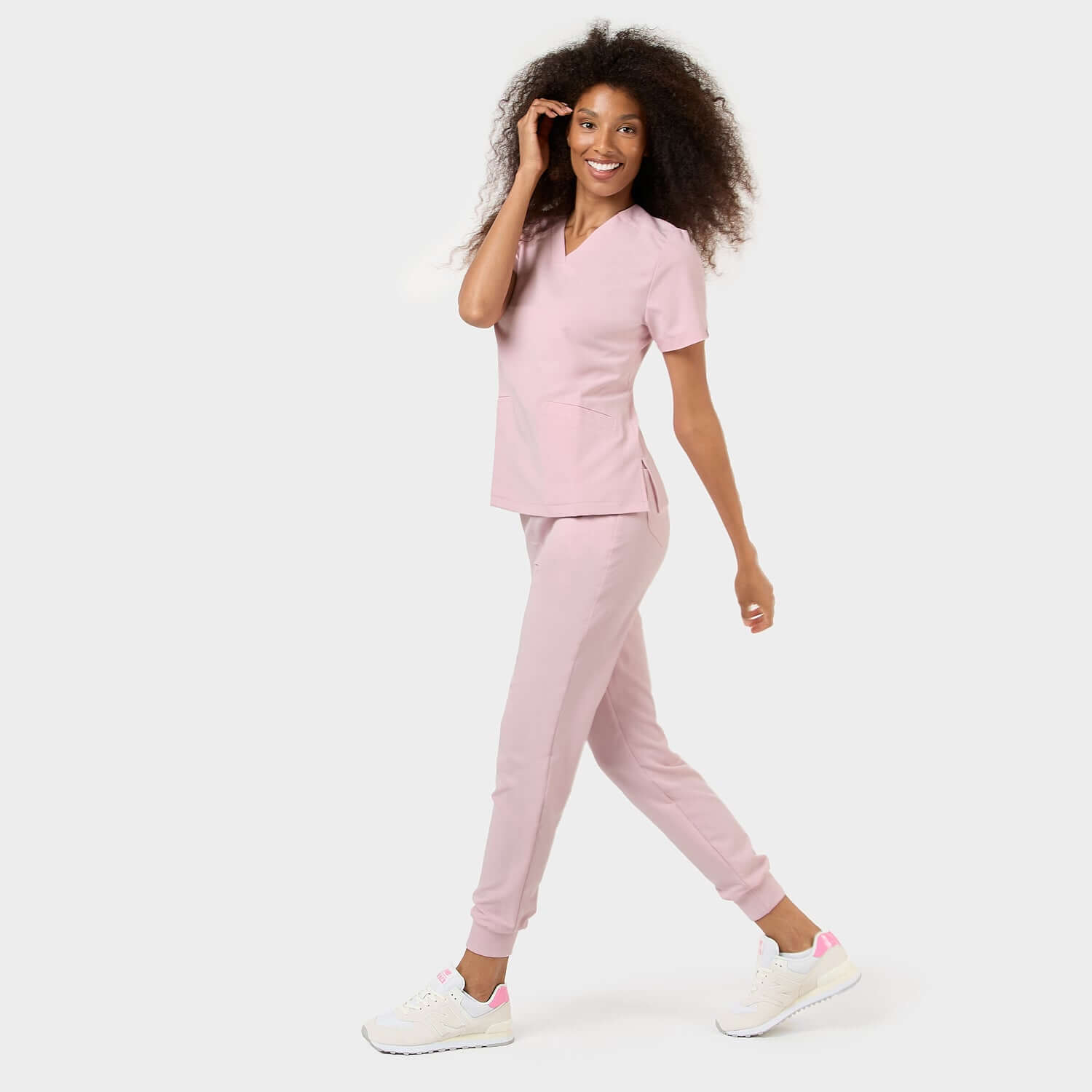 Dynamiczne zdjęcie kobiety w bluzie medycznej EMILY w kolorze Pastel Pink.